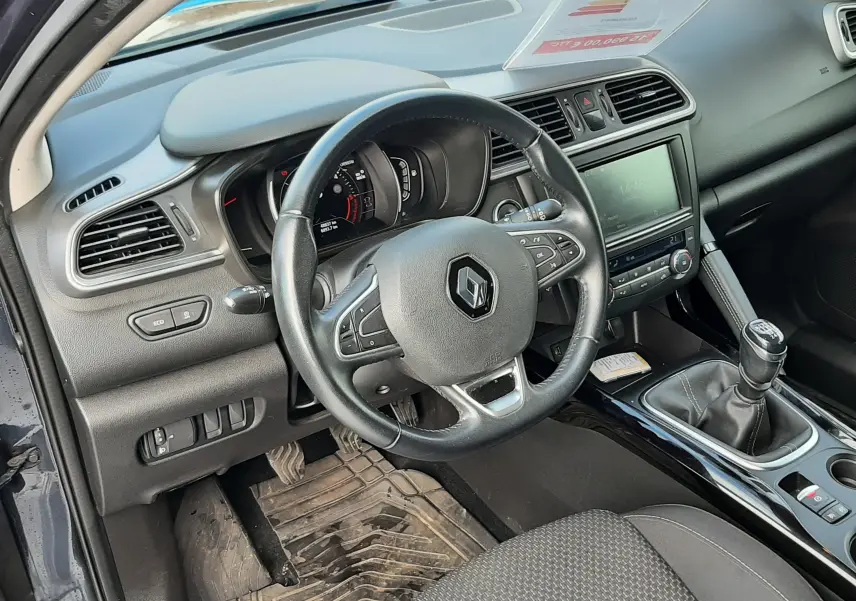 Intérieur côté conducteur du Renault Kadjar gris 2018, volant multifonction, tableau de bord et levier de vitesse manuel visibles.