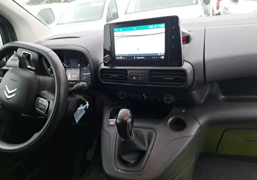 Vue intérieure côté conducteur du Citroën Berlingo blanc 2019, avec tableau de bord et écran tactile central affichant la navigation.
