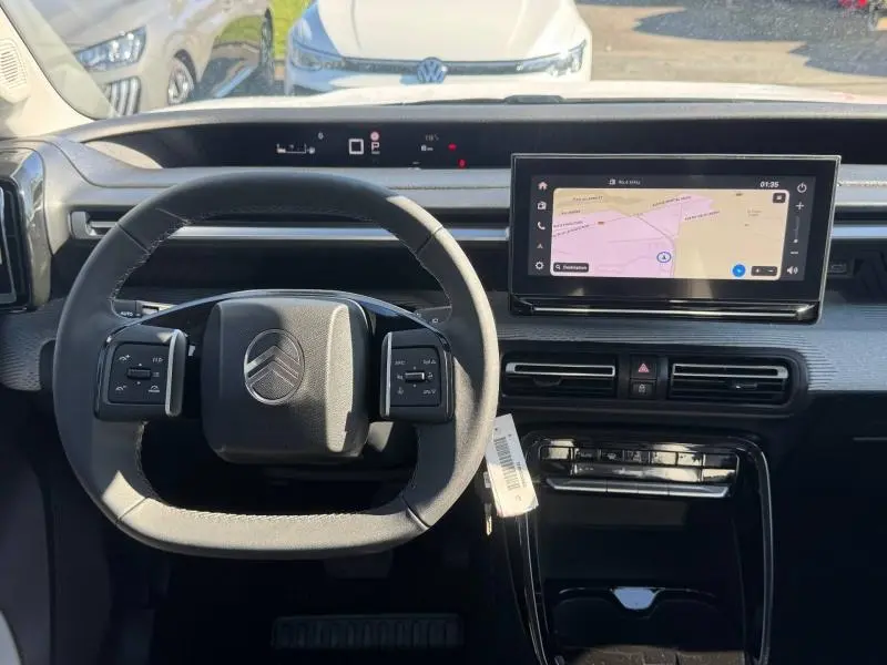 Vue intérieure centrée sur le volant multifonction et l'écran tactile du tableau de bord du Citroën C3 Aircross blanc.