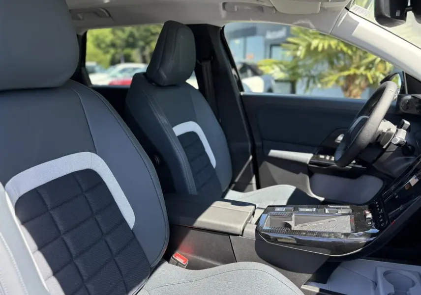 Vue intérieure côté conducteur du Citroën C5 Aircross noir Perla, sièges tissu bleu avec console centrale et volant multifonctions.
