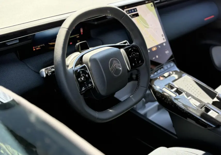 Vue rapprochée de l’intérieur du Citroën C5 Aircross hybride, volant multifonctions noir et écran tactile vertical.