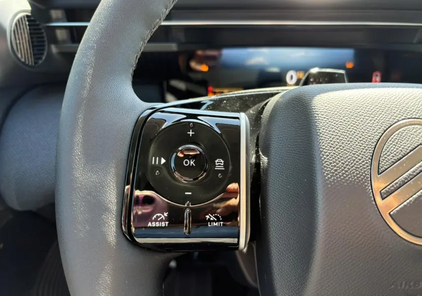 Gros plan sur les commandes multifonctions noires à gauche du volant gris du Citroën C5 Aircross 2026.
