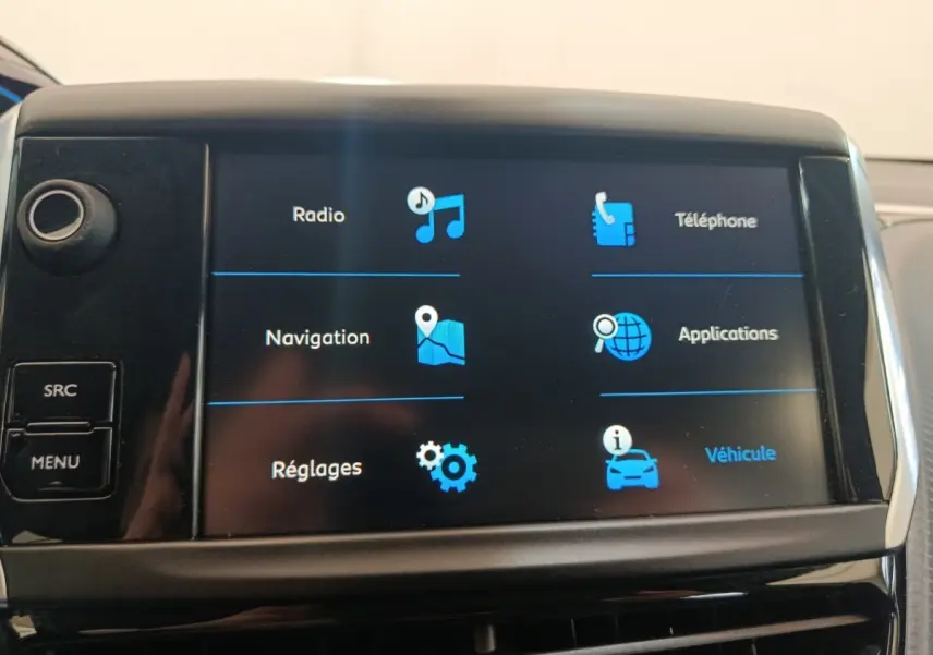 Écran tactile central du tableau de bord du Peugeot 2008 gris foncé, affichant les options radio, navigation et téléphone.