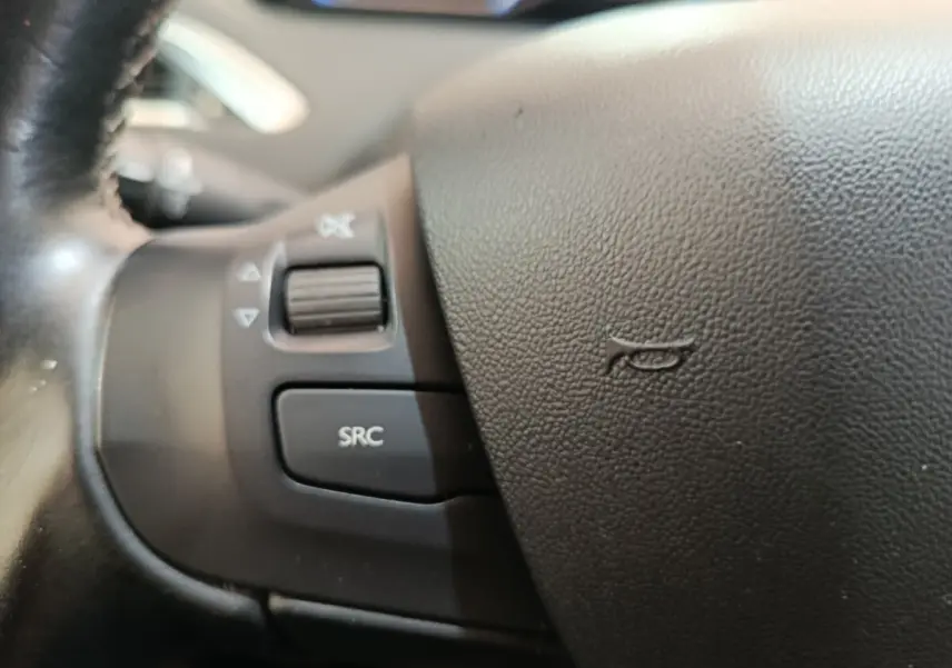 Gros plan sur les commandes audio du volant cuir noir du Peugeot 2008 gris foncé, version Puretech 110 S&S EAT6 Allure.