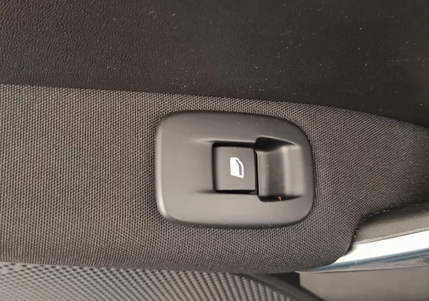 Gros plan sur le bouton d'ouverture de coffre intérieur, tissu noir, Peugeot 2008 gris foncé 2019.