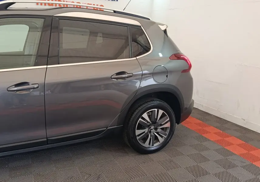 Vue côté droit arrière d’un Peugeot 2008 gris foncé avec jante alliage et vitres teintées.