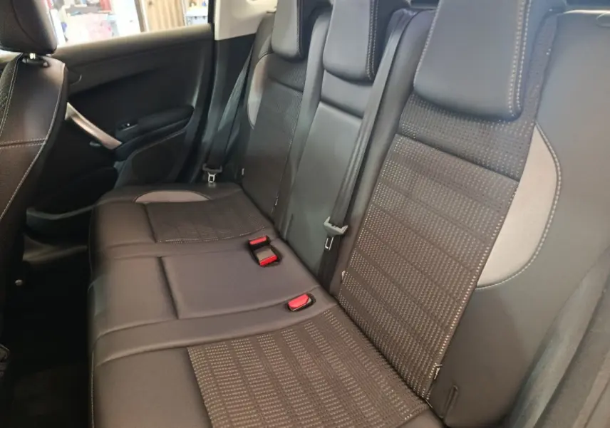 Vue intérieure côté droit sur la banquette arrière en cuir noir avec surpiqûres contrastantes du Peugeot 2008 gris foncé.