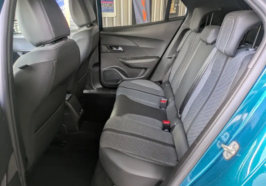 Vue intérieure arrière côté droit du Peugeot 2008 Hybrid 145 bleu obsession, sellerie tissu et cuir gris avec surpiqûres contrastées.