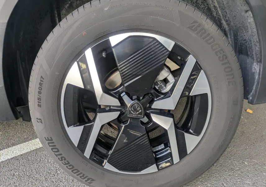 Gros plan sur la jante alliage 17'' bicolore noire et argentée du Peugeot 2008 Hybrid 145 Bleu Obsession.