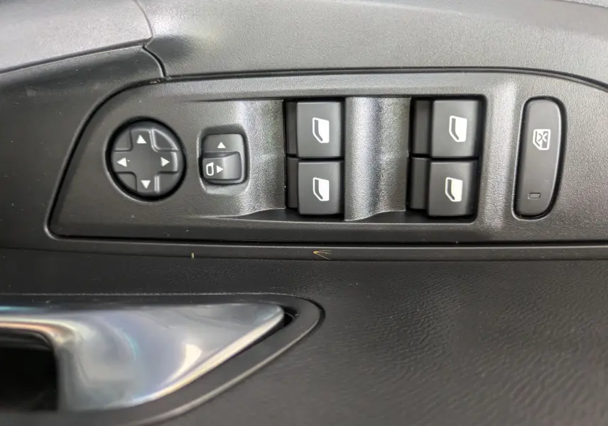 Gros plan sur les commandes de lève-vitres et rétroviseurs côté conducteur du Peugeot 2008 Hybrid 145 finition Allure.