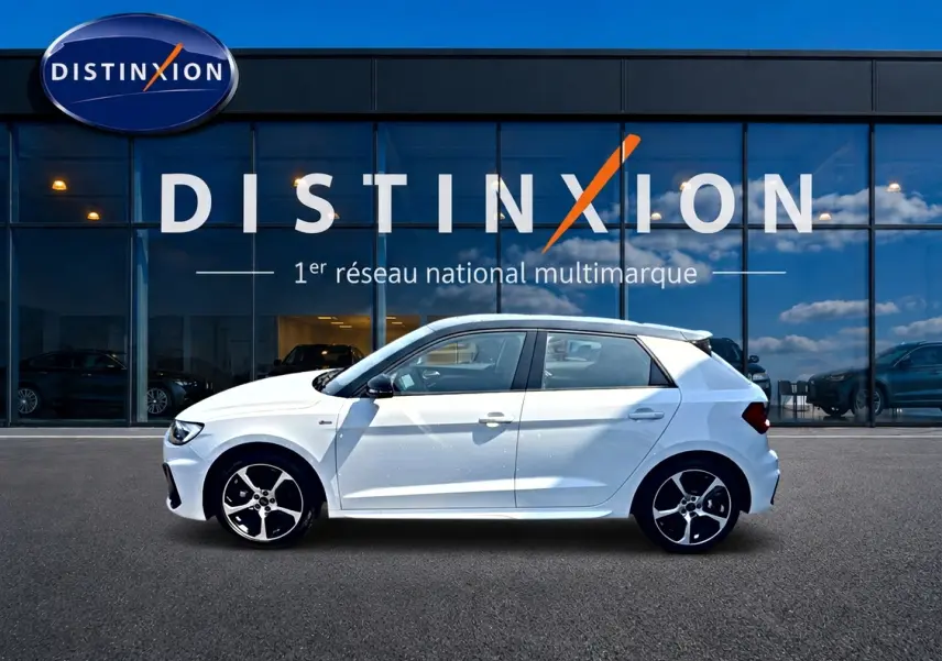 Audi A1 Sportback blanc avec toit noir en vue profil côté gauche devant une vitrine Distinxion.