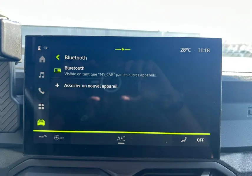 Écran tactile central du Dacia Duster 2025 affichant le menu Bluetooth, avec tableau de bord en arrière-plan.