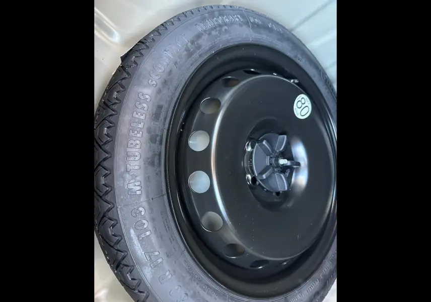 Gros plan sur la roue de secours noire du Dacia Duster 2025, avec pneu tubeless et étiquette de vitesse 80 km/h.