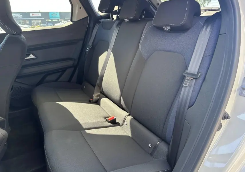 Vue latérale droite de la banquette arrière en tissu noir et bleu du Dacia Duster 2025, avec ceintures de sécurité visibles.