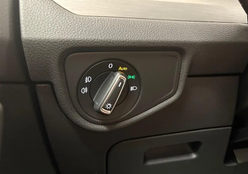 Gros plan sur le sélecteur d'éclairage intérieur noir du Volkswagen Touran 2025, avec réglage automatique activé.