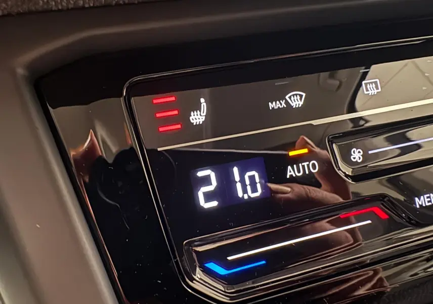 Affichage numérique de la climatisation automatique à 21°C avec siège chauffant activé dans un Volkswagen Touran 2025 gris dauphin.