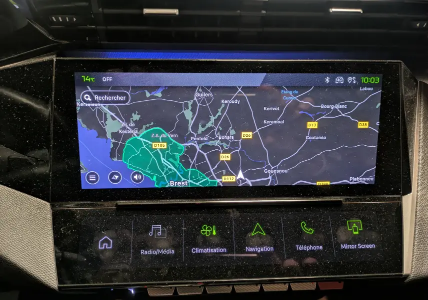 Gros plan sur le volant perforé noir de la Peugeot 308 SW Hybrid 145 eDCS6 GT, avec commandes intégrées visibles.