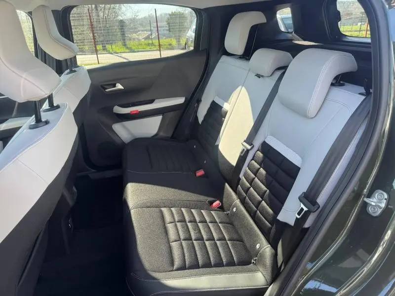 Vue intérieure arrière côté gauche du Citroën C3 Aircross 2026, sièges bicolores noir et blanc, tissu matelassé.