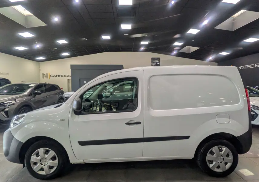 Vue latérale droite du Renault Kangoo Express blanc minéral 2020 en version Blue dCi 95 CH Grand Confort dans un showroom.