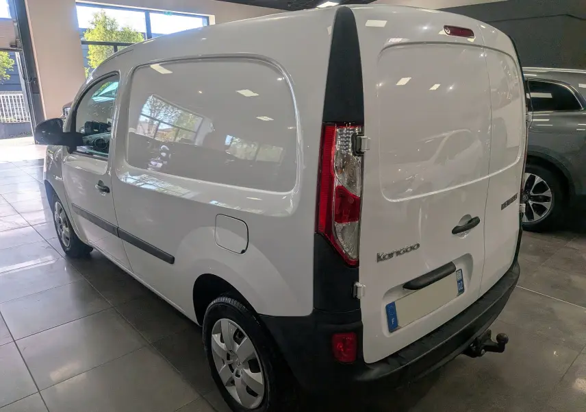 Vue 3/4 arrière droite d’un Renault Kangoo Express blanc Minéral, utilitaire compact avec hayon arrière fermé en intérieur showroom.