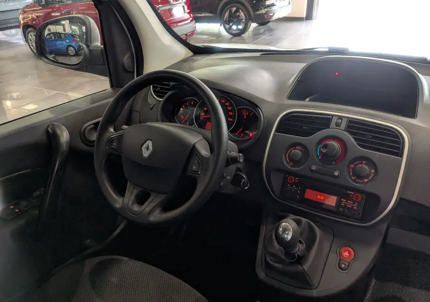 Vue intérieure du tableau de bord et volant du Renault Kangoo Express 2020 avec boîte manuelle et commandes de climatisation visibles.