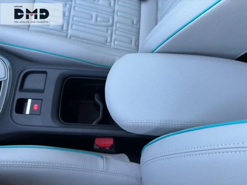 Gros plan intérieur sur l'accoudoir central ivoire avec surpiqûres bleues et siège FIAT 600 hybride 2026.