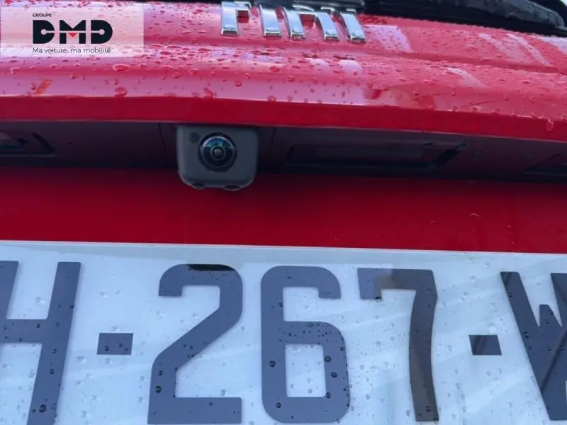 Gros plan sur la caméra de recul intégrée au hayon rouge de la FIAT 600, avec plaque d’immatriculation visible.