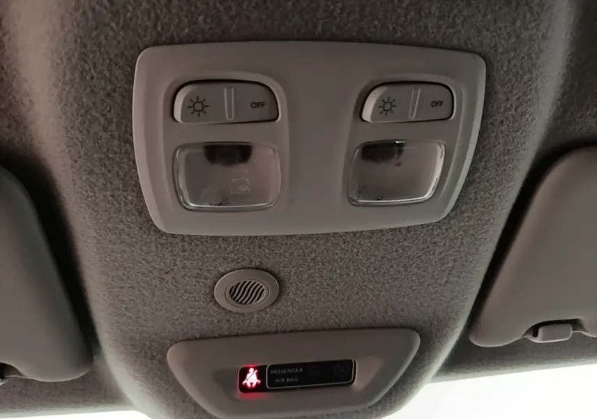 Plafonnier intérieur avec éclairages de lecture et témoin d'airbag passager du Dacia Duster blanc, vue vers le toit.