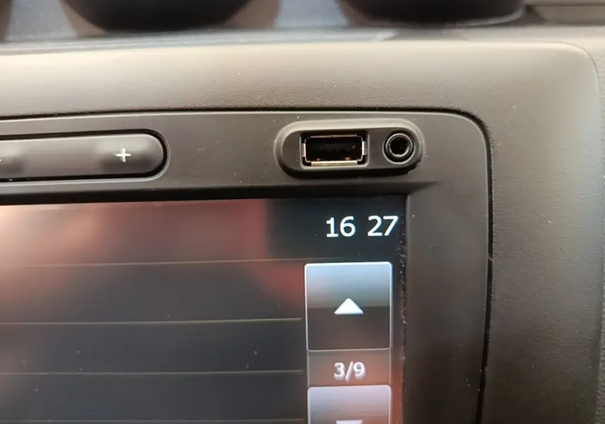 Gros plan sur l’écran tactile central avec port USB et prise jack du Dacia Duster blanc, version Confort Blue dCi 115 4x4.