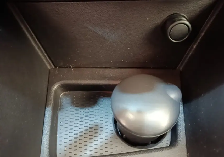 Gros plan sur le levier de vitesses manuel noir du Dacia Duster Confort Blue dCi 115 4x4, intérieur sombre.