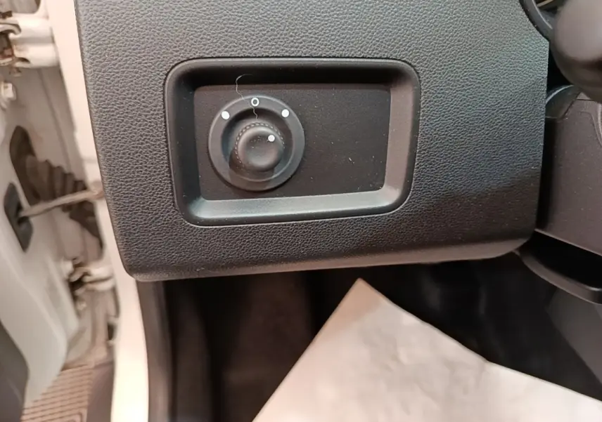 Détail du réglage des rétroviseurs côté conducteur du Dacia Duster blanc, intérieur côté gauche.