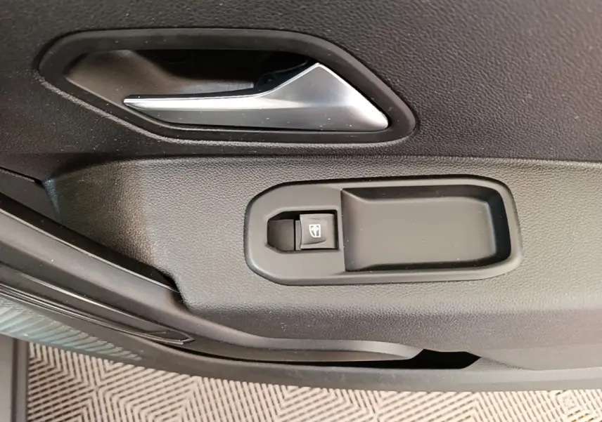 Détail de la poignée intérieure et commande de lève-vitre côté conducteur du Dacia Duster blanc 2021.