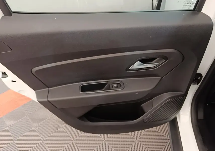 Vue rapprochée de la porte arrière droite blanche du Dacia Duster 2021 avec commande de vitre et haut-parleur intégré.