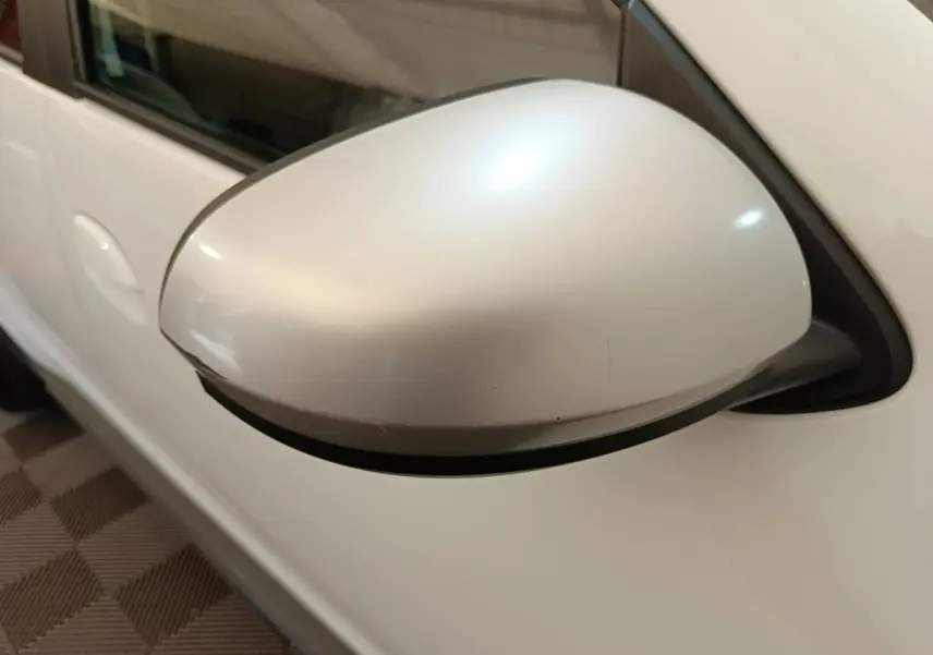 Gros plan sur le rétroviseur droit blanc du Dacia Duster Confort Blue dCi 115 4x4 de 2021.