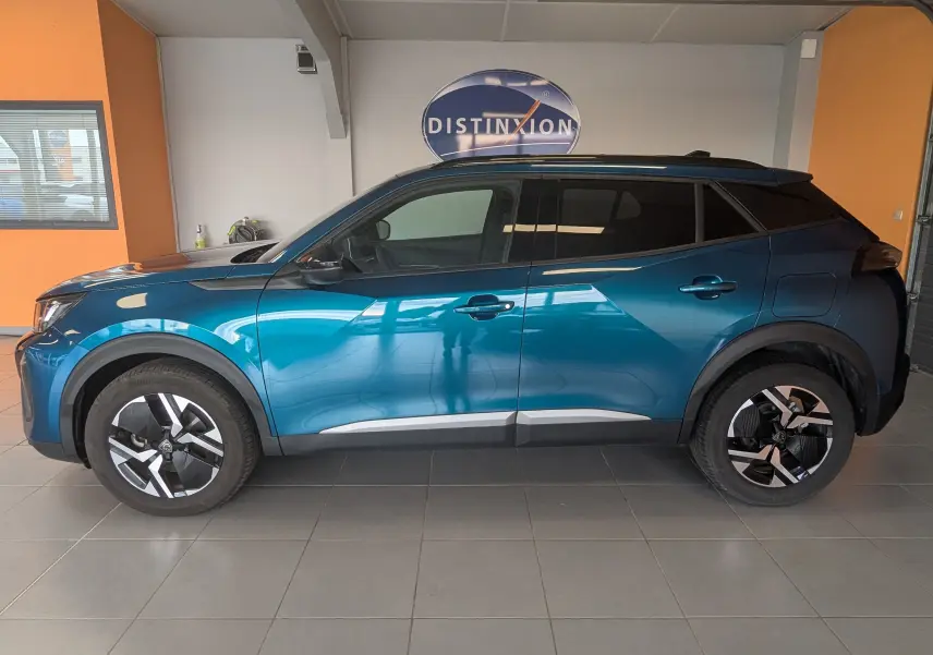 Vue de profil côté gauche du Peugeot 2008 Hybrid 145 bleu Obsession avec jantes alliage 17'' et vitres surteintées.