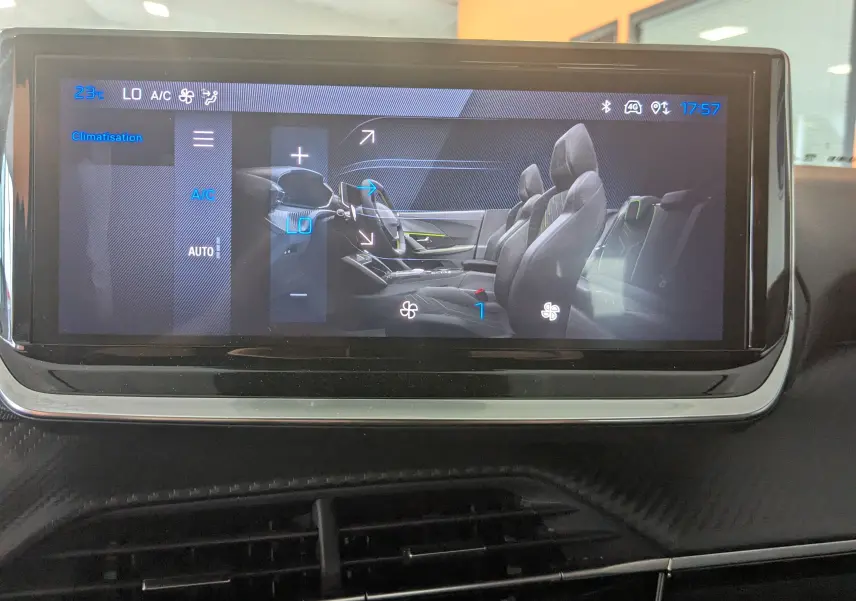 Écran tactile intérieur du Peugeot 2008 Hybrid 145 montrant la commande de climatisation et la vue latérale des sièges gris-noir.