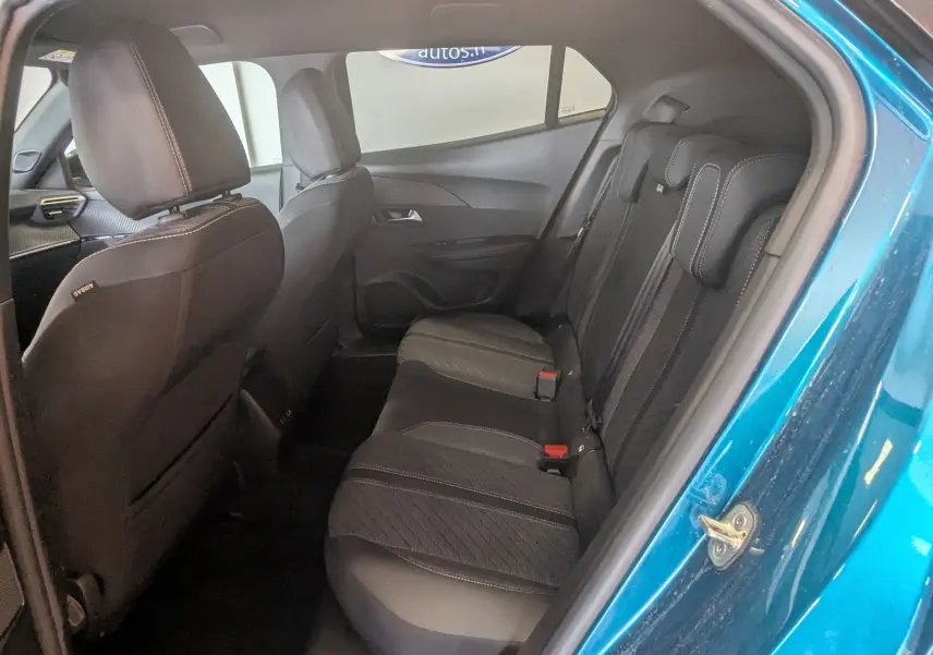Vue intérieure côté gauche des sièges arrière en tissu gris noir d'un Peugeot 2008 Hybrid 145 Bleu Obsession avec portière ouverte.