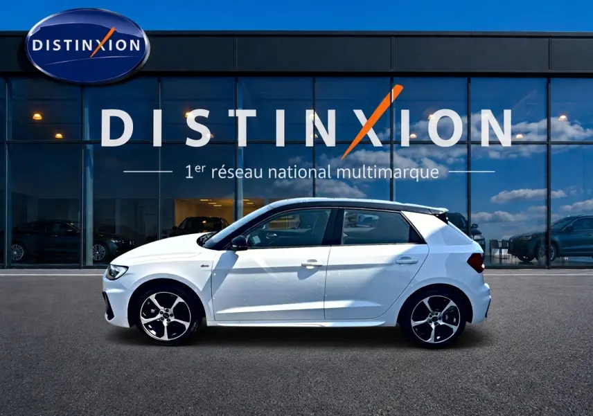 Audi A1 Sportback blanc et noir vue de profil côté gauche devant une vitrine avec logo Distinxion.