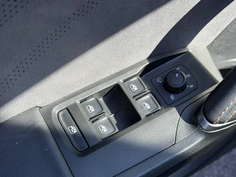 Gros plan sur les commandes des vitres électriques et réglage des rétroviseurs côté conducteur du CUPRA Formentor 1.5 eTSI Hybrid 2025.