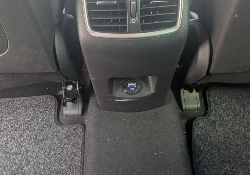 Vue rapprochée de la console centrale arrière noire du Hyundai Tucson 2019 avec bouches d’aération et prise USB.