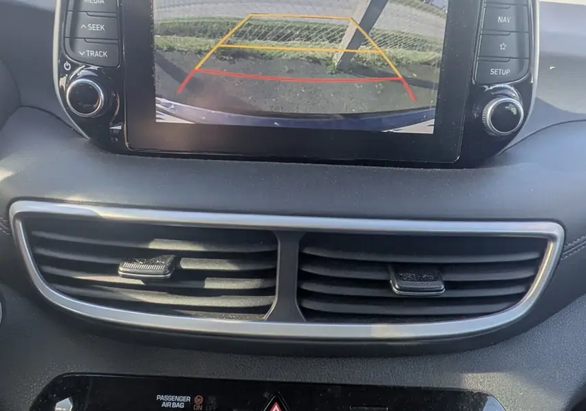 Vue intérieure du tableau de bord du Hyundai Tucson noir 2019 avec écran tactile affichant la caméra de recul.