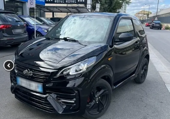 Vue 3/4 avant d'une LIGIER JS50 Sport pack DCI noire avec jantes alu 15" VEGA, doubles essuie-glaces et calandre distinctive.