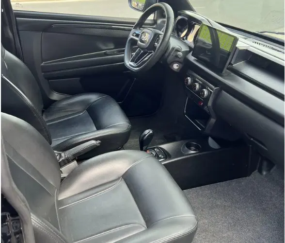 Intérieur noir de la Ligier JS50 Sport pack DCI 2024, vue côté gauche montrant sièges cuir, volant et écran tactile central.