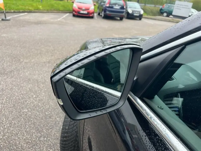 Rétroviseur côté gauche noir Magic Nacré du Skoda Kodiaq 2018 avec gouttes d'eau sur carrosserie et vitre.