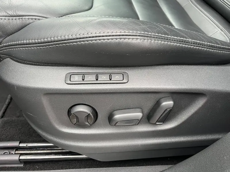 Gros plan sur les commandes de réglage électrique du siège conducteur en cuir noir du Skoda Kodiaq noir Magic Nacré.