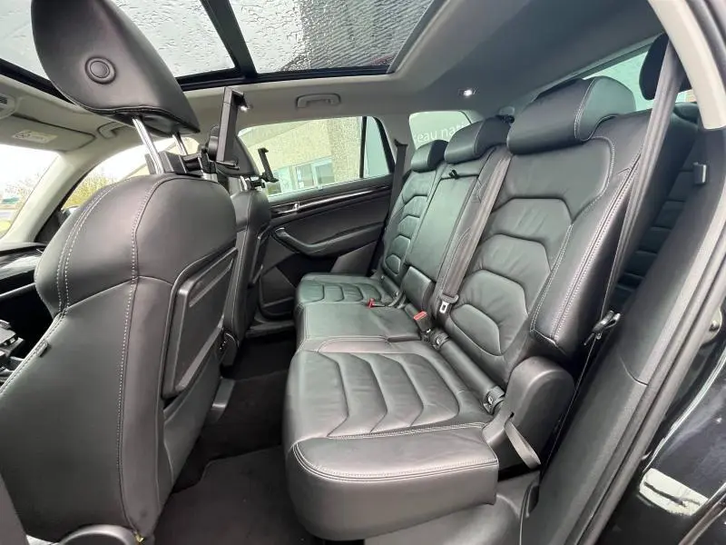 Vue intérieure côté droit des sièges arrière en cuir noir du Skoda Kodiaq 2018 avec toit panoramique en verre.