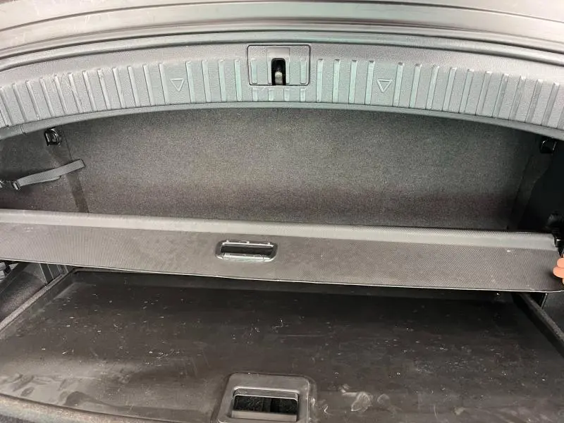 Vue intérieure du coffre du Skoda Kodiaq noir Magic Nacré, montrant la tablette cache-bagages partiellement relevée.