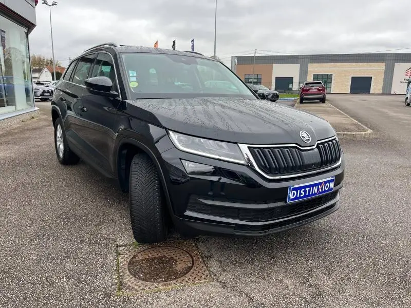 Vue 3/4 avant d’un Skoda Kodiaq noir Magic Nacré garé, mettant en valeur sa calandre chromée et ses phares LED.