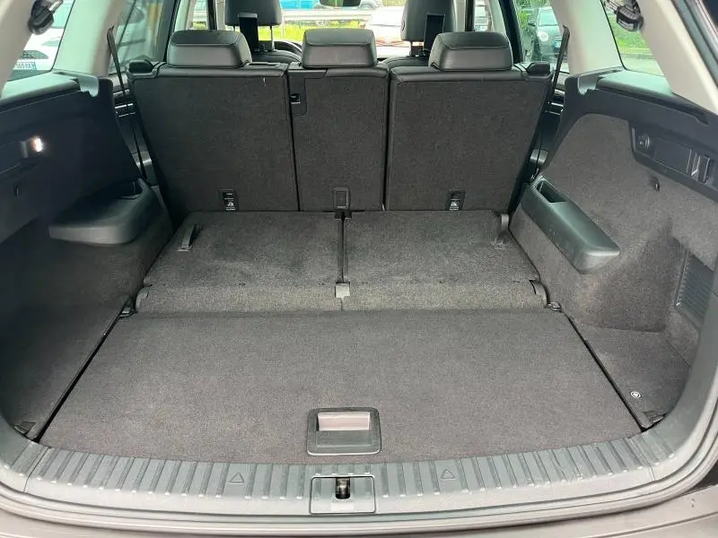 Coffre ouvert vu de l'arrière du Skoda Kodiaq noir Magic Nacré, montrant la banquette arrière en position relevée.