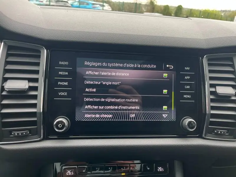 Écran tactile central du tableau de bord du Skoda Kodiaq noir, affichant les réglages d'aide à la conduite.